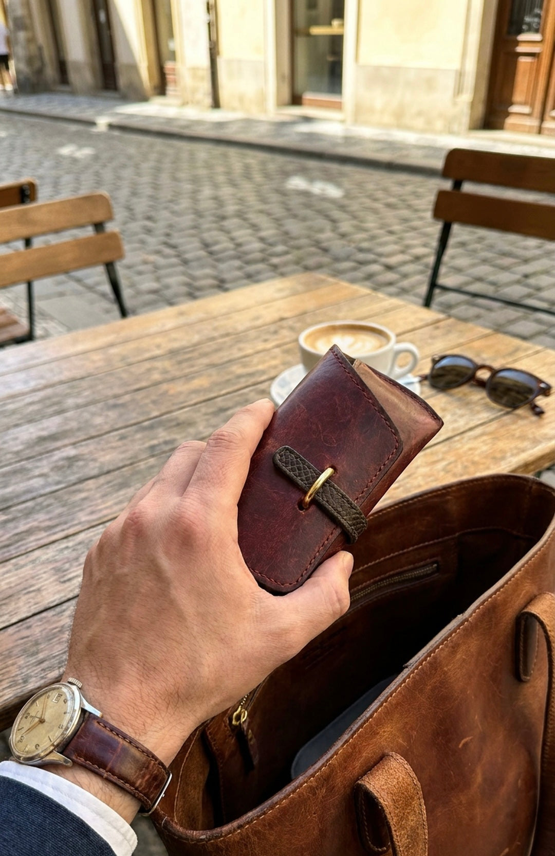 Leather wallet showing a burnished patina on its corners and spine from daily carry