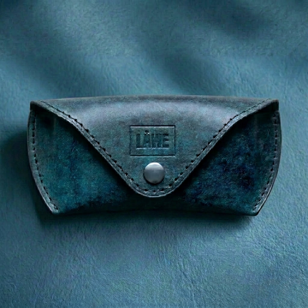 Blue leather eyewear case with a button on a blue background