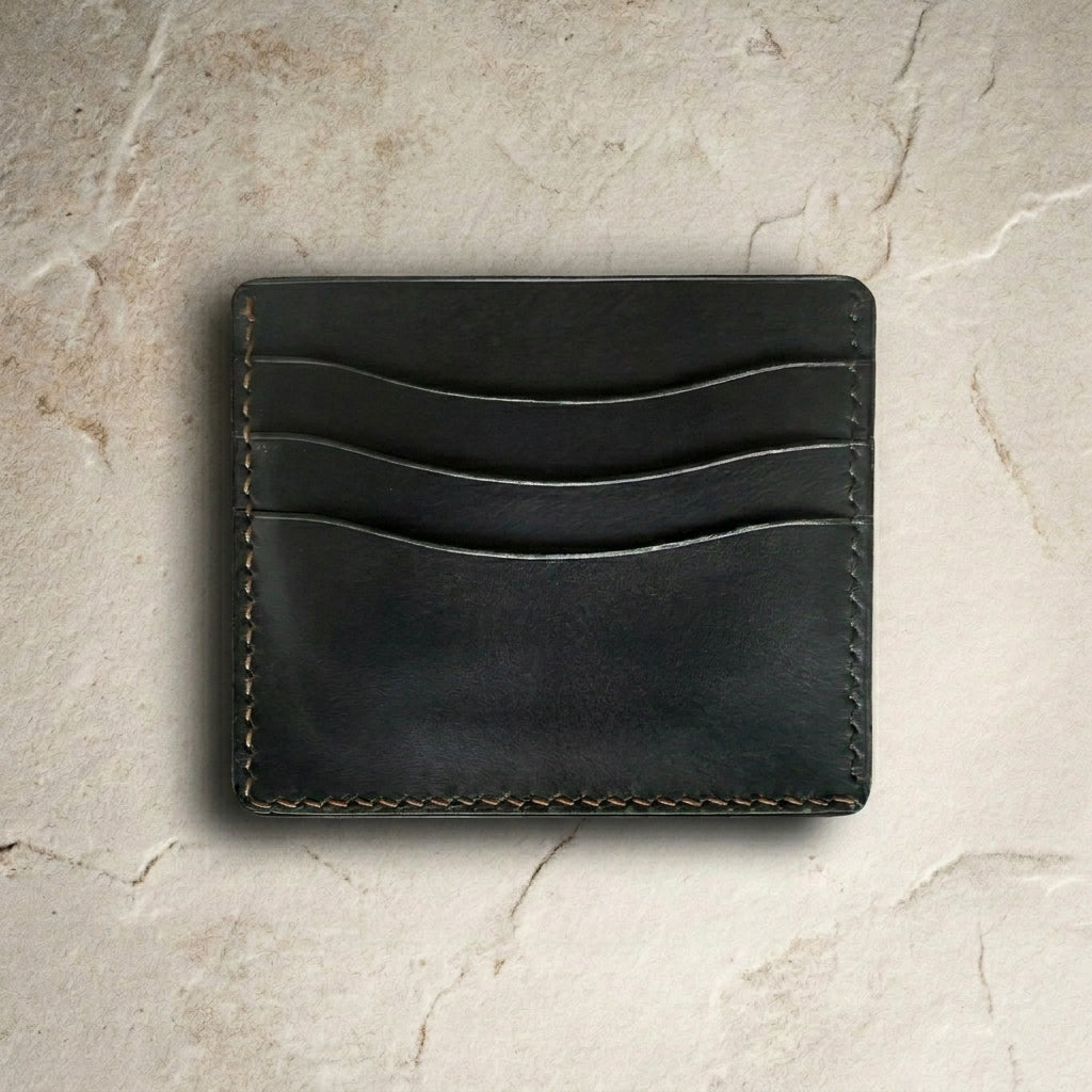 LÅWE Axis Left Handed onlyx leather cardholder on a light stone surface