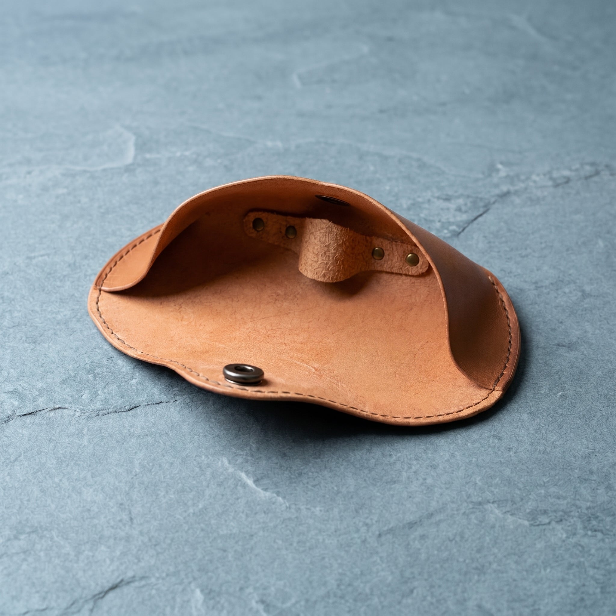 Warm brown leather case on a textured grey stone surface