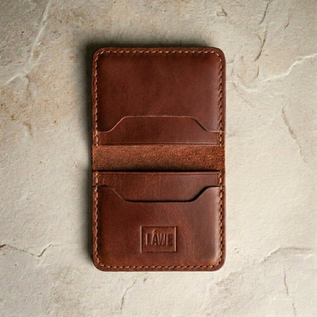 LÅWE Cognac Classic Edge - warm brown leather wallet with a visible brand logo on a stone surface