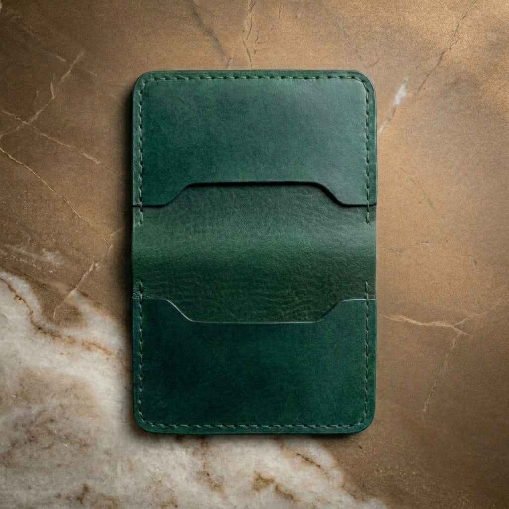 LÅWE Forest Edge - green leather cardholder on a textured bronze surface