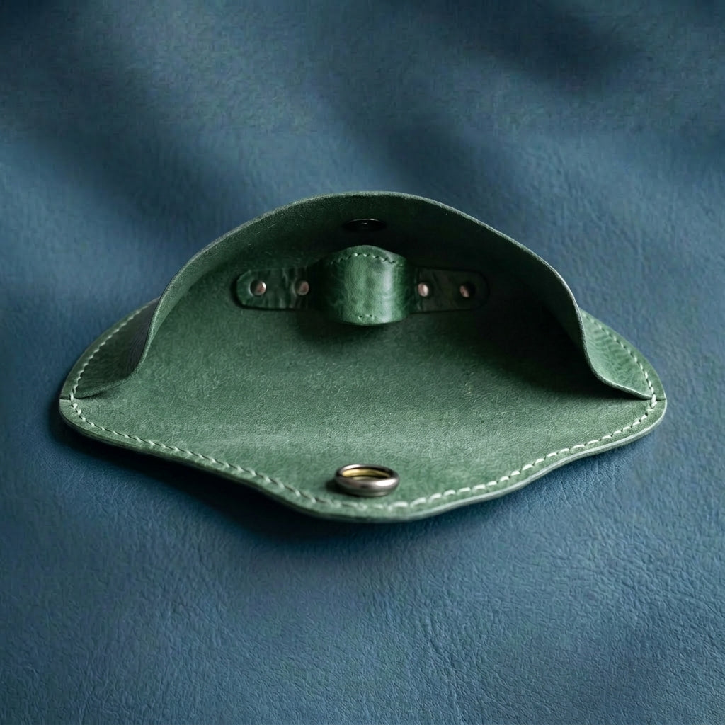 Green leather eyewear case on a blue background