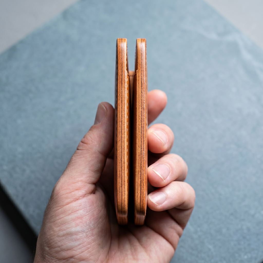 LÅWE Honey Edge - hand showing burnished edges of the leather wallet on a grey stone