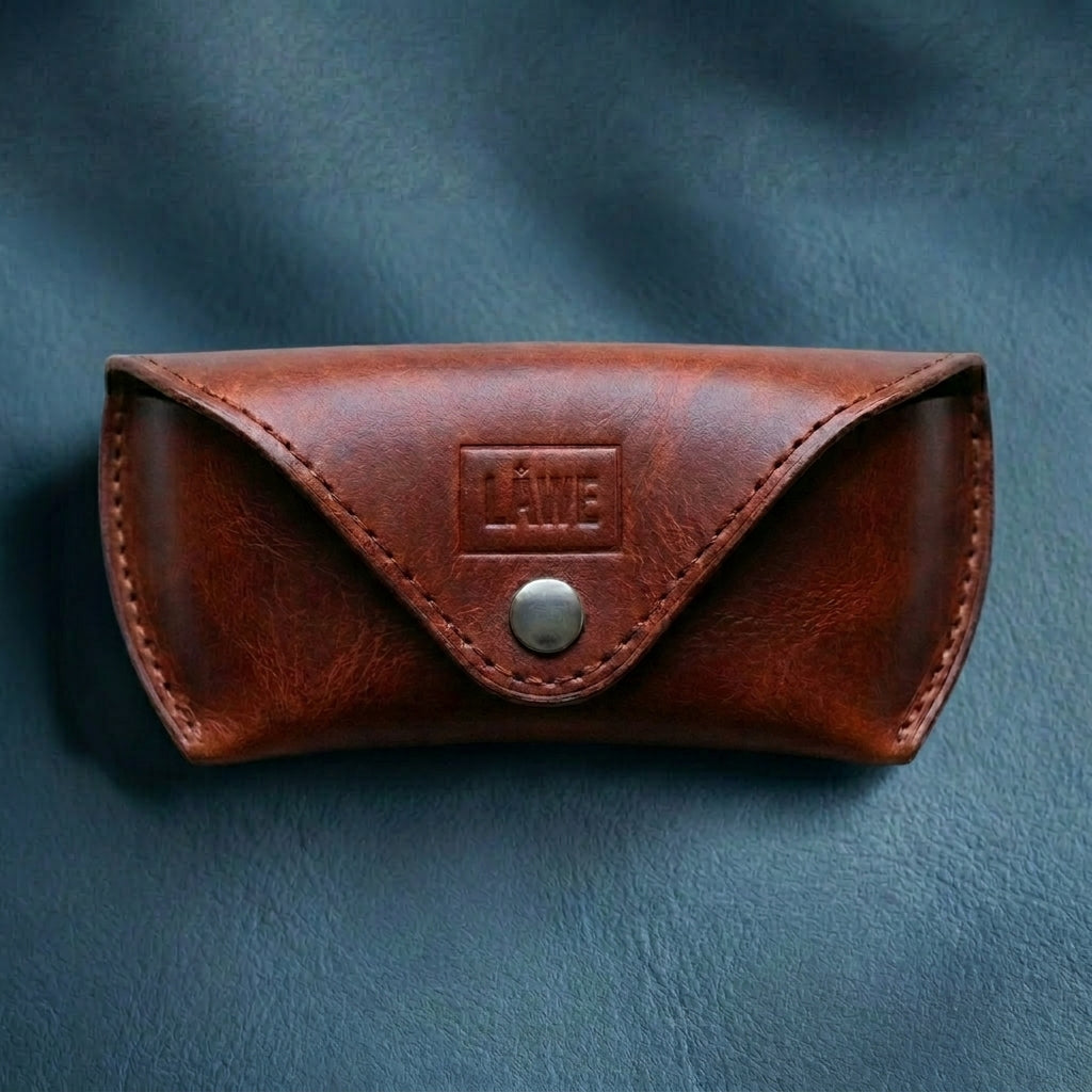 Brown leather eyewear case with a metal button on a dark blue background