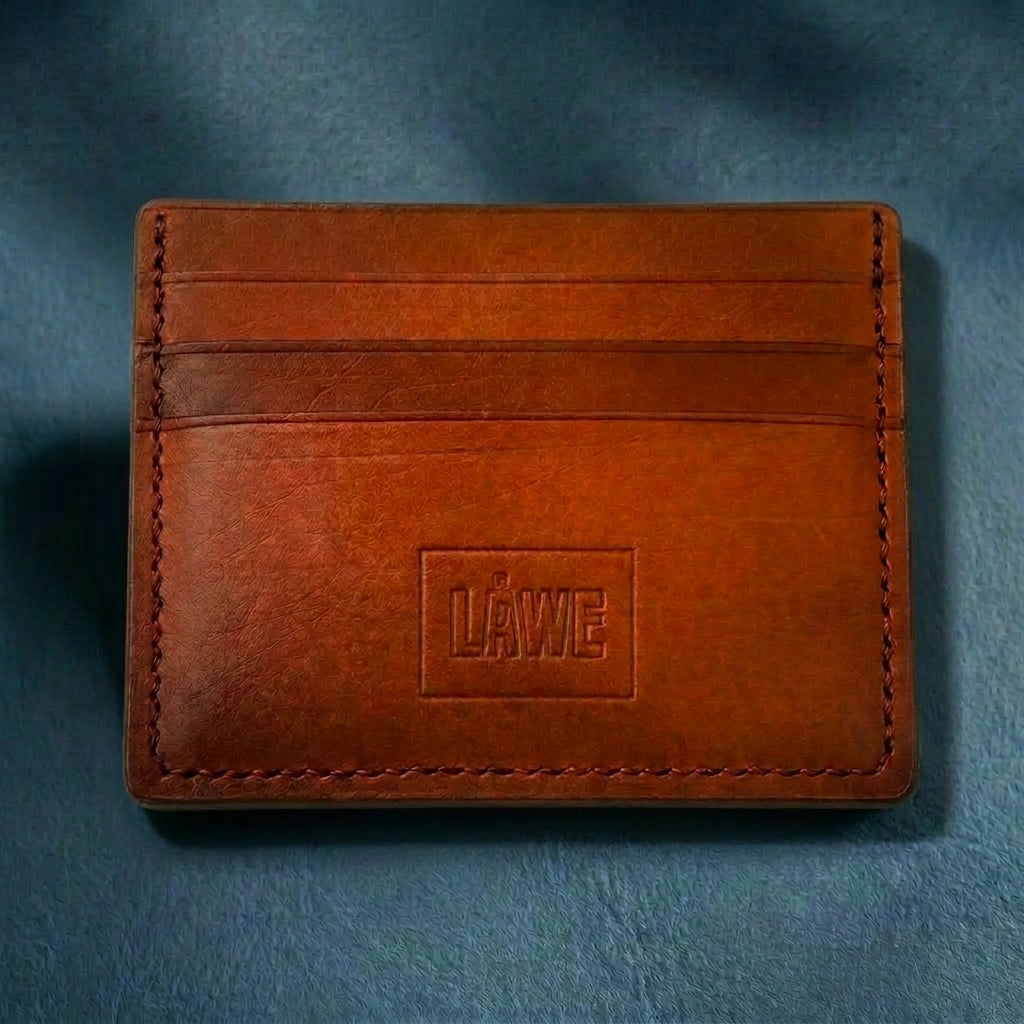 Orange toned brown leather cardholder with 'LÅWE' branding on a blue background