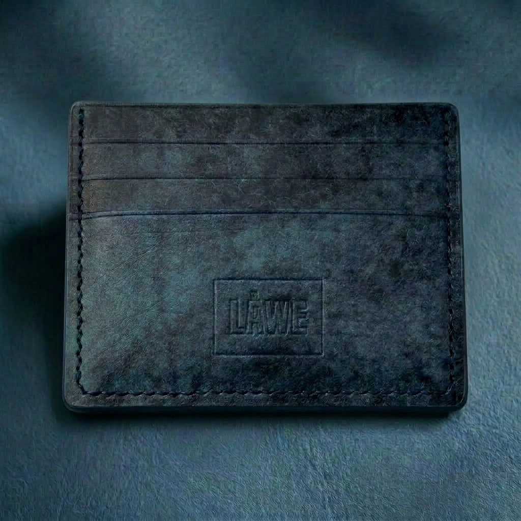 Dark blue leather cardholder with 'LÅWE' branding on a matching background