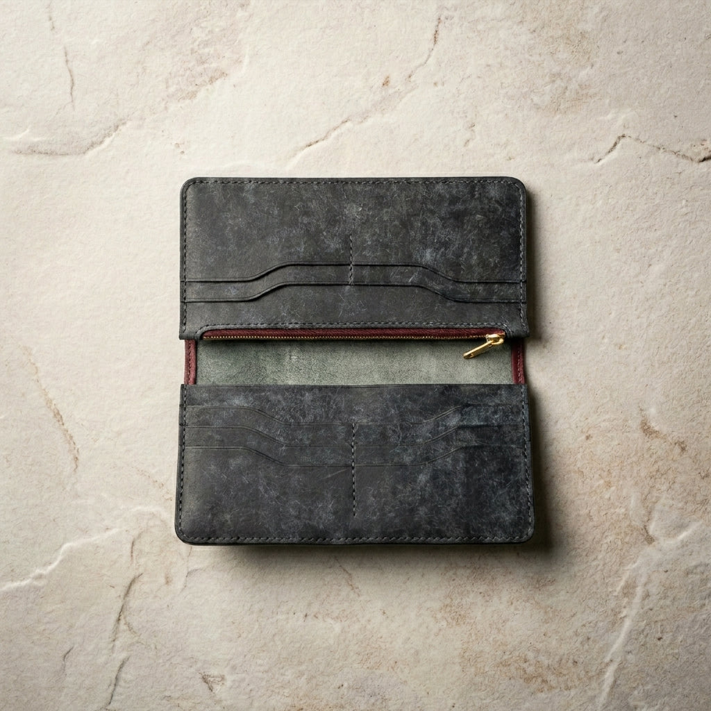 Slate LÅWE Span long leather wallet with a zipper on a beige stone surface